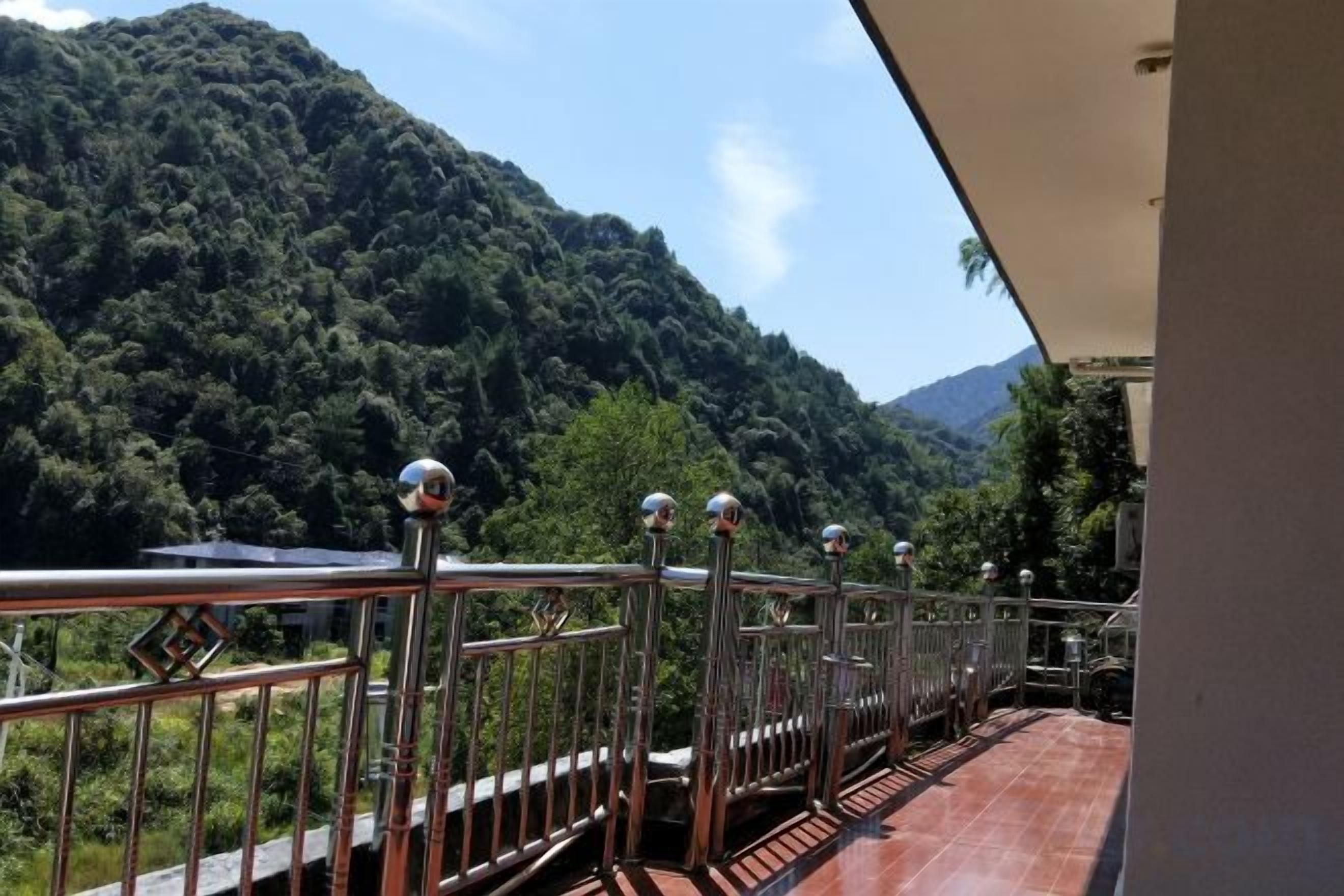 Un balcone con ringhiera in metallo che si affaccia su un paesaggio montuoso.