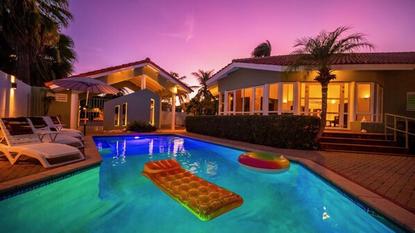 A swimming pool with lounge chairs and an inflatable float.