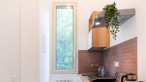 Une cuisine de taille réduite, dotée d’une fenêtre, d’une cuisinière encastrée et d’un radiateur.