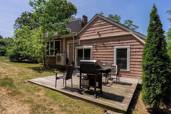 A house with a deck, outdoor grill, and patio furniture. - Spacious Two Bedroom Apartment (Wayland)