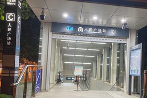 A metro station entrance with a sign indicating the station name and a pedestrian crossing. - City Boutique Hotel(Dalian Railway Station People Saunare Subway Branch (Dalian)