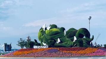 Uma grande escultura em forma de elefante, verde, com uma placa que diz 'WELCOME'.