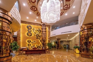 A lobby with a reception desk, a large decorative wall, and a staircase. - Xixiangfeng International Hotel (Pingxiang Railway Station) (Pingxiang)