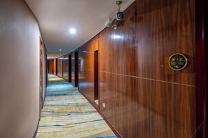 Un pasillo de hotel con paredes de madera y suelo alfombrado.