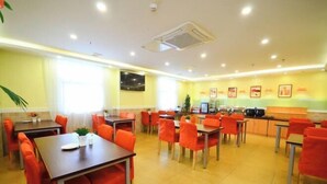 A dining area with multiple tables and chairs, a kitchen area, and a TV mounted on the wall. - Home Inn Piper Cloud (Xuzhou Dibei Xianghe Branch) (Xuzhou)