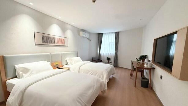 A hotel room with two beds, a desk, a chair, a TV, and a window with curtains. - Home Inn Piper Cloud (Xuzhou Dibei Xianghe Branch) (Xuzhou)