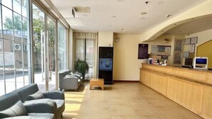A reception area with a counter, seating, and large windows. - Home Inn Piper Cloud (Xuzhou Dibei Xianghe Branch) (Xuzhou)