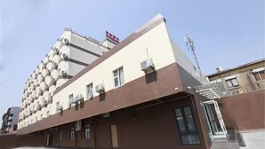A multi-story hotel with a modern architectural design, featuring a prominent entrance with glass doors and a ramp leading to the main building. - Home Inn Piper Cloud (Xuzhou Dibei Xianghe Branch) (Xuzhou)