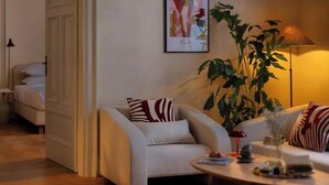 A modern living room with a sofa, a coffee table, and a lamp. There is a door leading to another room.