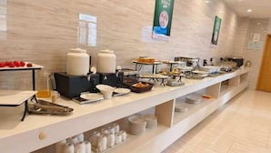 A buffet setup with various food items and containers. - Yoke Hotel (Taiyuan)