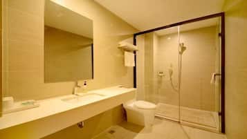 Een moderne badkamer met een grote spiegel, een wastafel, een toilet en een douchecabine.