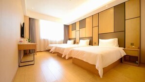 A hotel room with two beds, a bedside table, a TV, and a window with curtains. - Yoke Hotel (Taiyuan)