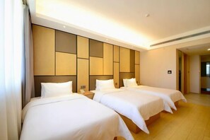 Habitación de hotel con dos camas, piso de madera y un diseño moderno en la pared.