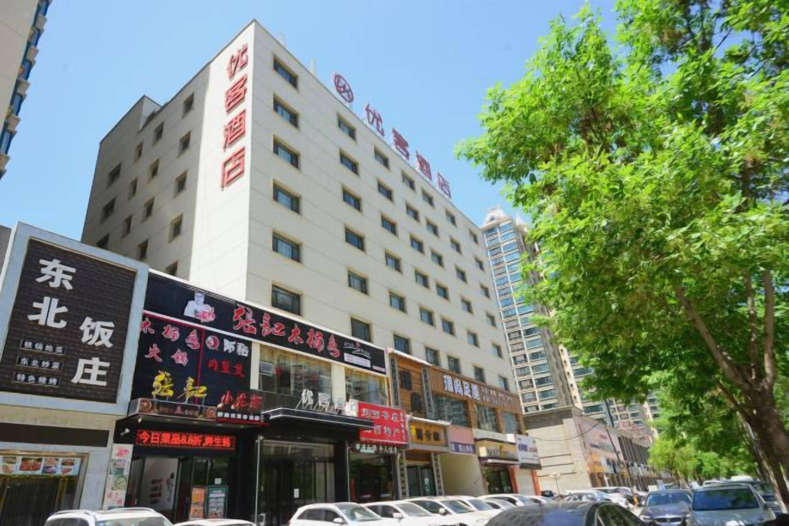 Un hotel de diversos pisos amb indicadors de diversos negocis a la planta baixa.