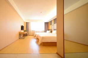 A hotel room with a large bed, a desk with a chair, a flat-screen TV, and a window with curtains. - Yoke Hotel (Taiyuan)