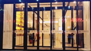 A hotel entrance with glass doors and a well-lit interior. - Yoke Hotel (Taiyuan)