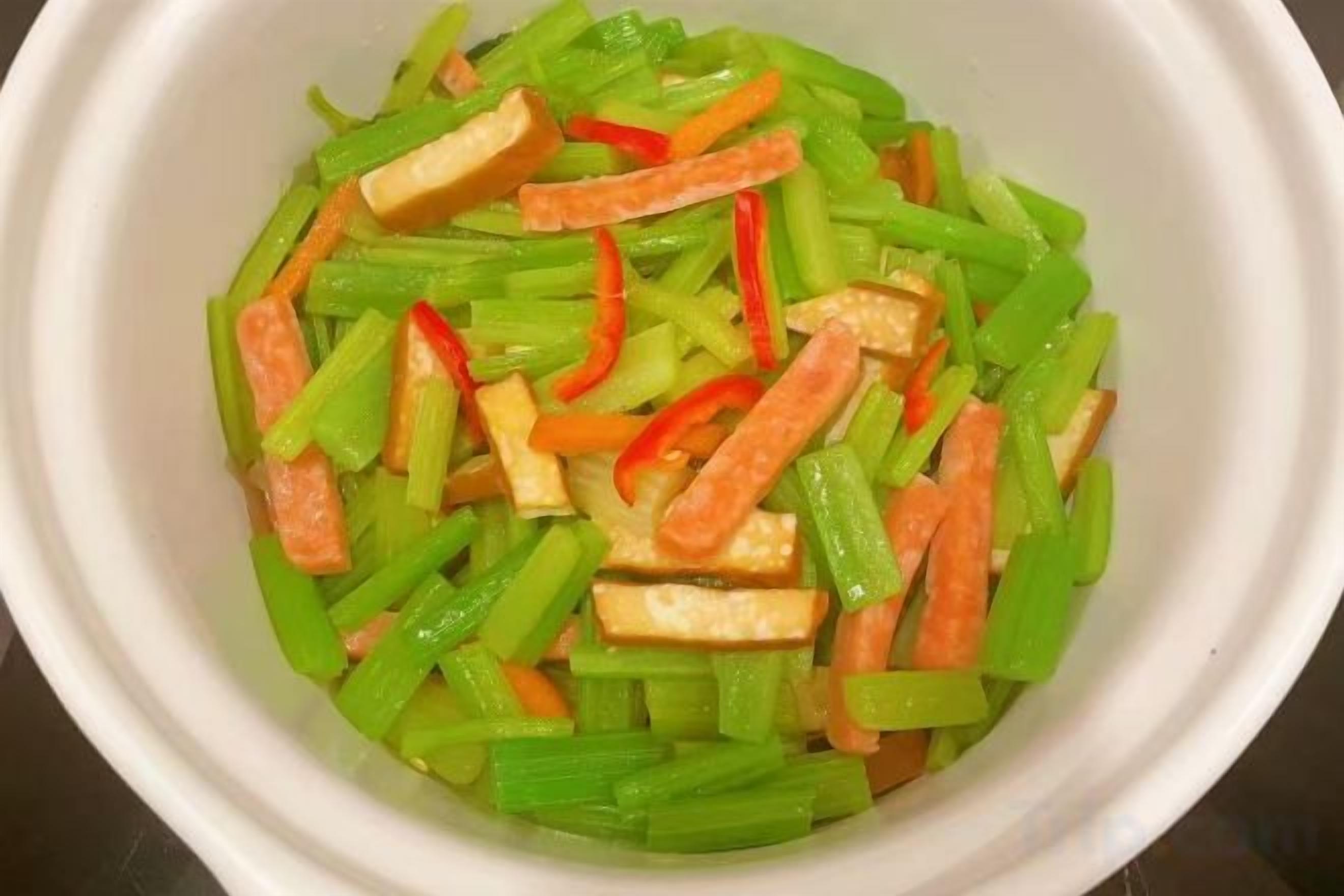 A white bowl containing sliced vegetables.