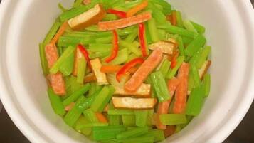 A white bowl containing sliced vegetables.