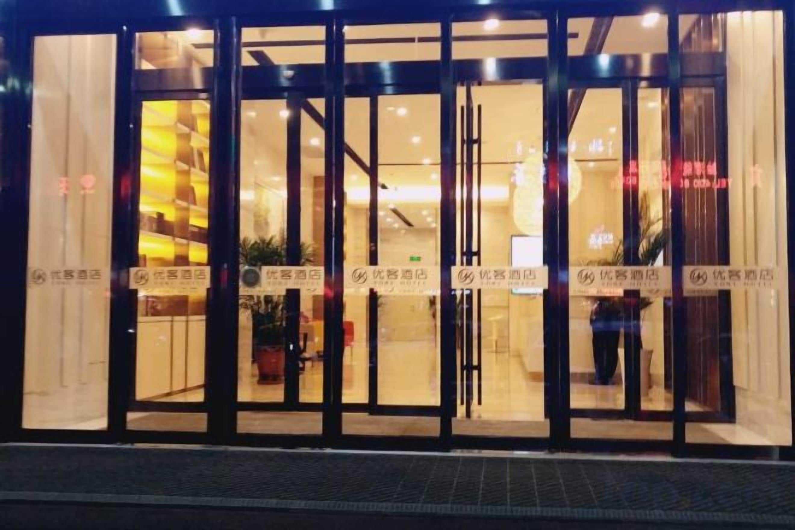 Entrada de hotel com portas de vidro e interior visível.