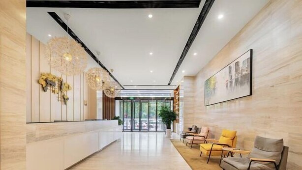 A modern hotel lobby with a reception desk, seating area, and a large window. - Yoke Hotel (Taiyuan)