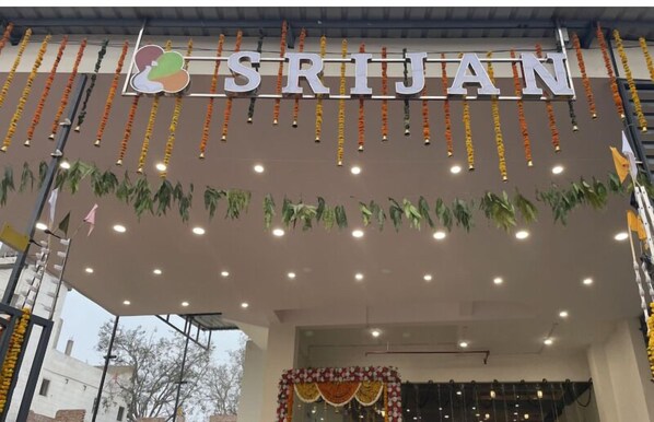 La entrada de un hotel con el nombre 'SRIJAN' bien visible en la parte superior.