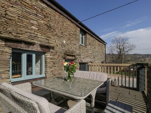 A stone building with a glass table and wicker furniture outside. - White Haywood Farm (Hereford)