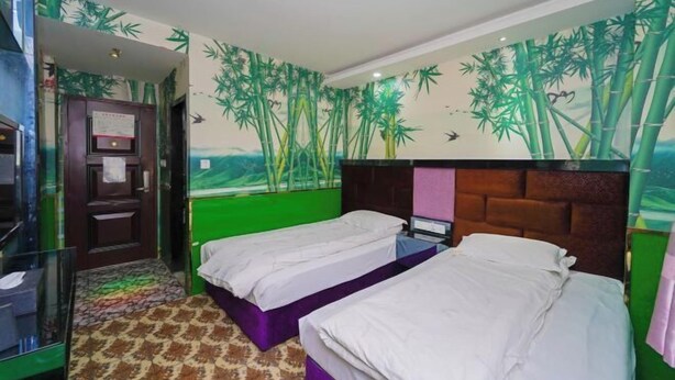 A room with two beds, a green wall, and a bamboo mural. - Hongman Fashion Hotel (Shanghai)