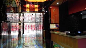 A reception area with a glass partition, a reception desk, and a ceiling with a decorative light fixture. - Hongman Fashion Hotel (Shanghai)