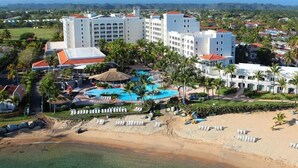 Un resort con piscina, playa y varios edificios.