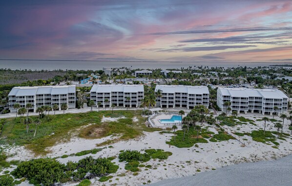 Un complexe hôtelier comprenant plusieurs bâtiments, une piscine et offrant une vue sur la plage.