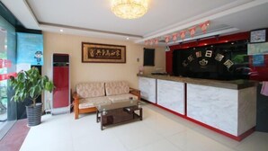 A hotel lobby with a reception desk, a sofa, a coffee table, and a chandelier. - Huile Holiday Hostel (Shanghai)