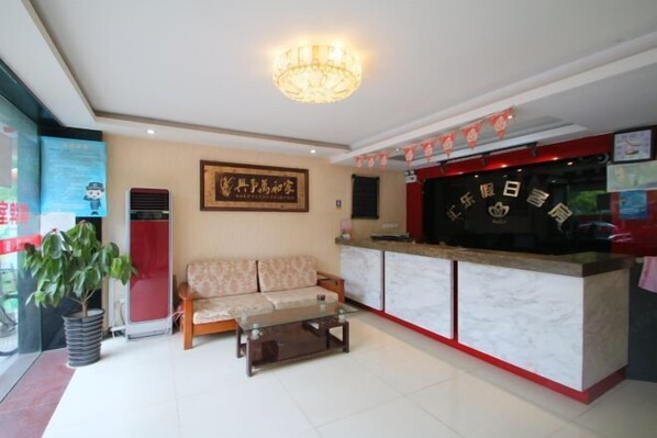 A hotel lobby with a reception desk, a sofa, a coffee table, and a chandelier. - Huile Holiday Hostel (Shanghai)