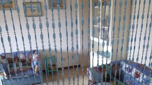 A room with a patterned sofa, a small table, and a decorative curtain. - Villetta Kala e Moru "Sa Oghe e su Mare" (Quartu Sant'Elena)