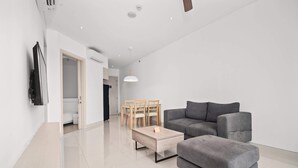 A modern living room with a grey sofa, a wooden coffee table, and a dining area with a table and chairs. - Cassia Residences, Two-Bedroom 1707 C Premium Lake (Choeng Thale)