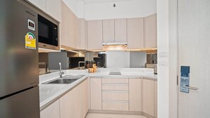A modern kitchen with stainless steel appliances, a microwave, and a built-in oven. - Cassia Residences, Two-Bedroom 1707 C Premium Lake (Choeng Thale)