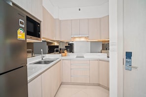 Une cuisine moderne équipée d’appareils électroménagers en acier inoxydable, d’un four à micro-ondes et d’un four encastré.