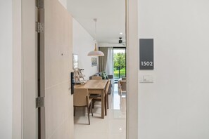 A modern interior with a dining area, a ceiling fan, and a view through a glass door. - Cassia Residences, Two-Bedroom 1502 D Deluxe Lake (Choeng Thale)