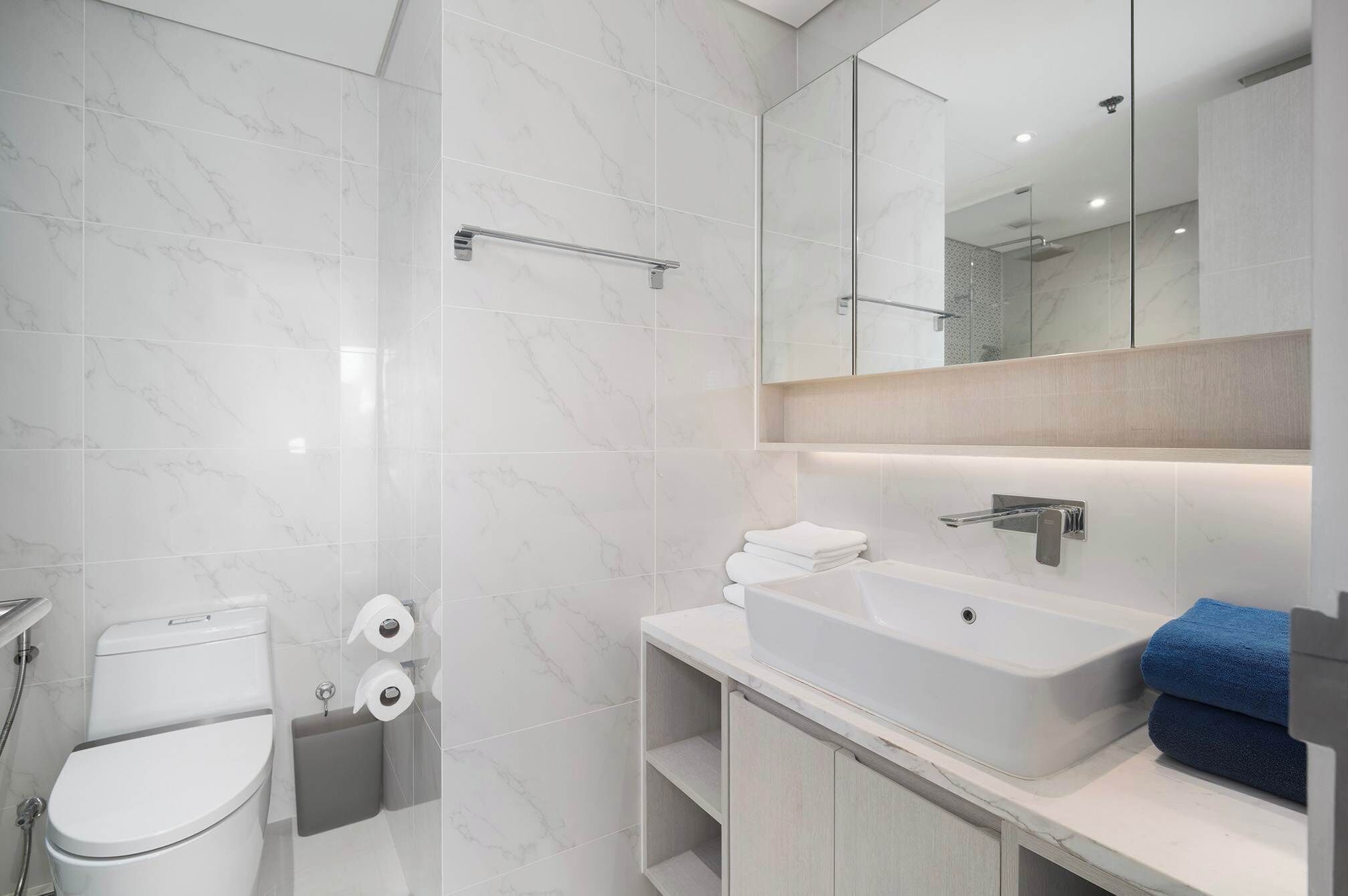 A modern bathroom with a toilet, bidet, and sink.