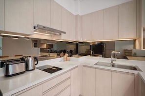 A modern kitchen with a central island, stainless steel appliances, and a large mirror.