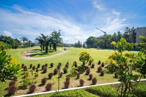 Ein Golfplatz, strahlend blauer Himmel, Palmen und ein Baukran im Hintergrund.