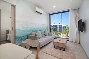 Un salon moderne avec un canapé, une table basse et un téléviseur fixé au mur.
