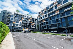 Een modern meerhooger gebouw met een parkeerplaats ervoor.