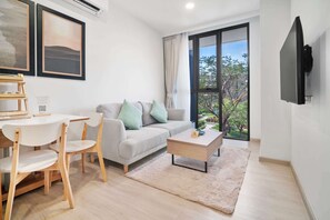 Ein modernes Wohnzimmer mit Sofa, Couchtisch und Essbereich.