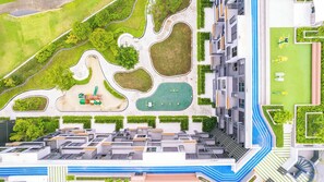 Ein moderner Wohnkomplex mit Innenhof, Grünflächen und einem Schwimmbad.