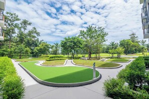 Een aangelegde tuin met een kronkelend pad, omgeven door groen en bomen.