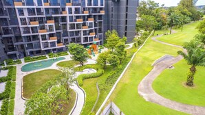 Un immeuble d’appartements moderne doté d’un terrain de jeux, d’espaces verts et d’un parcours de golf.