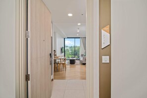 Een modern interieur met een houten vloer, een eethoek met tafel en stoelen, en een zithoek met een bank en een televisie.