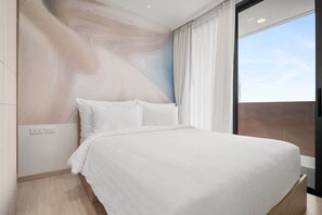 A modern bedroom with a large bed, a view of the sky through a window, and a unique wall design.