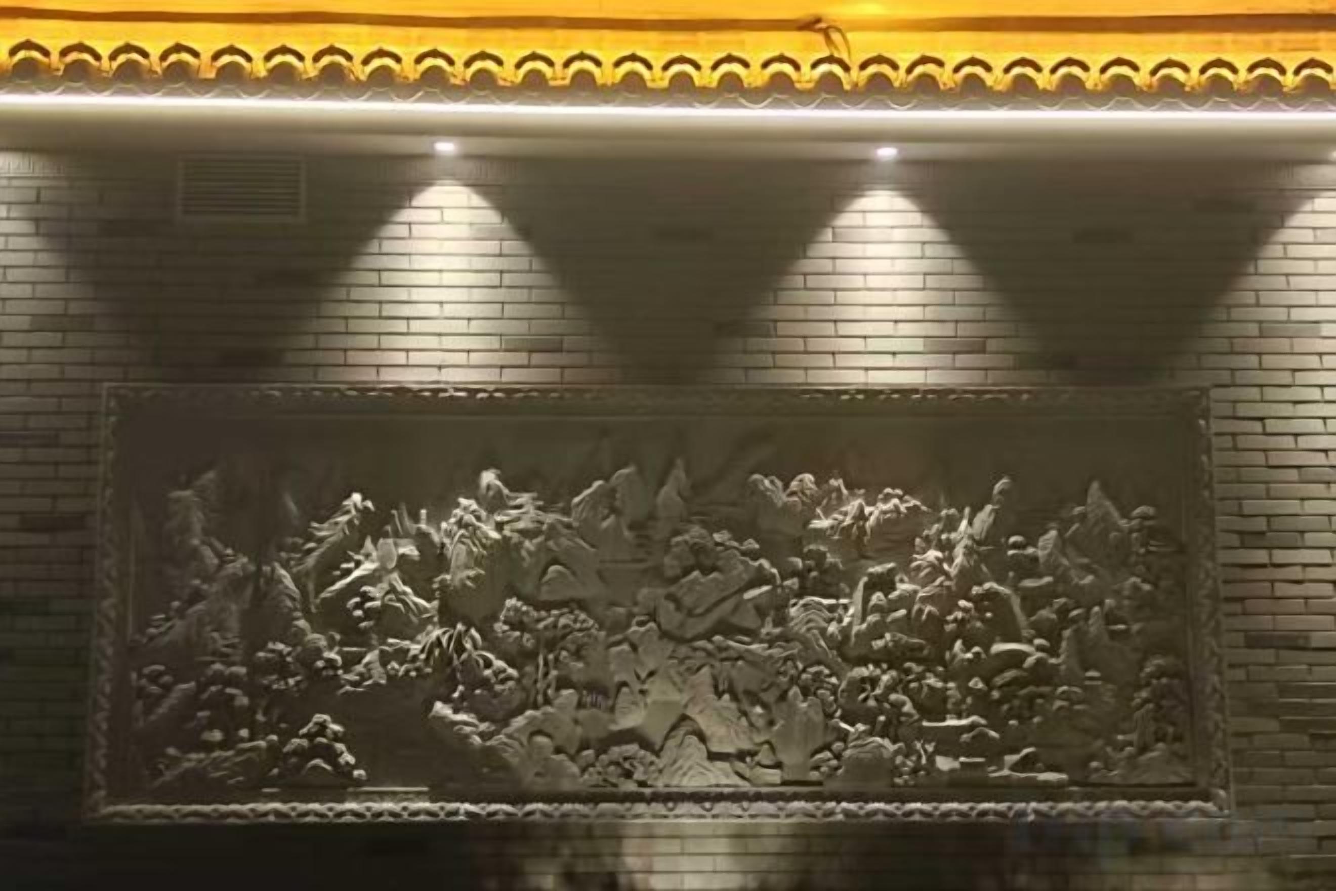 A wall with a relief sculpture.