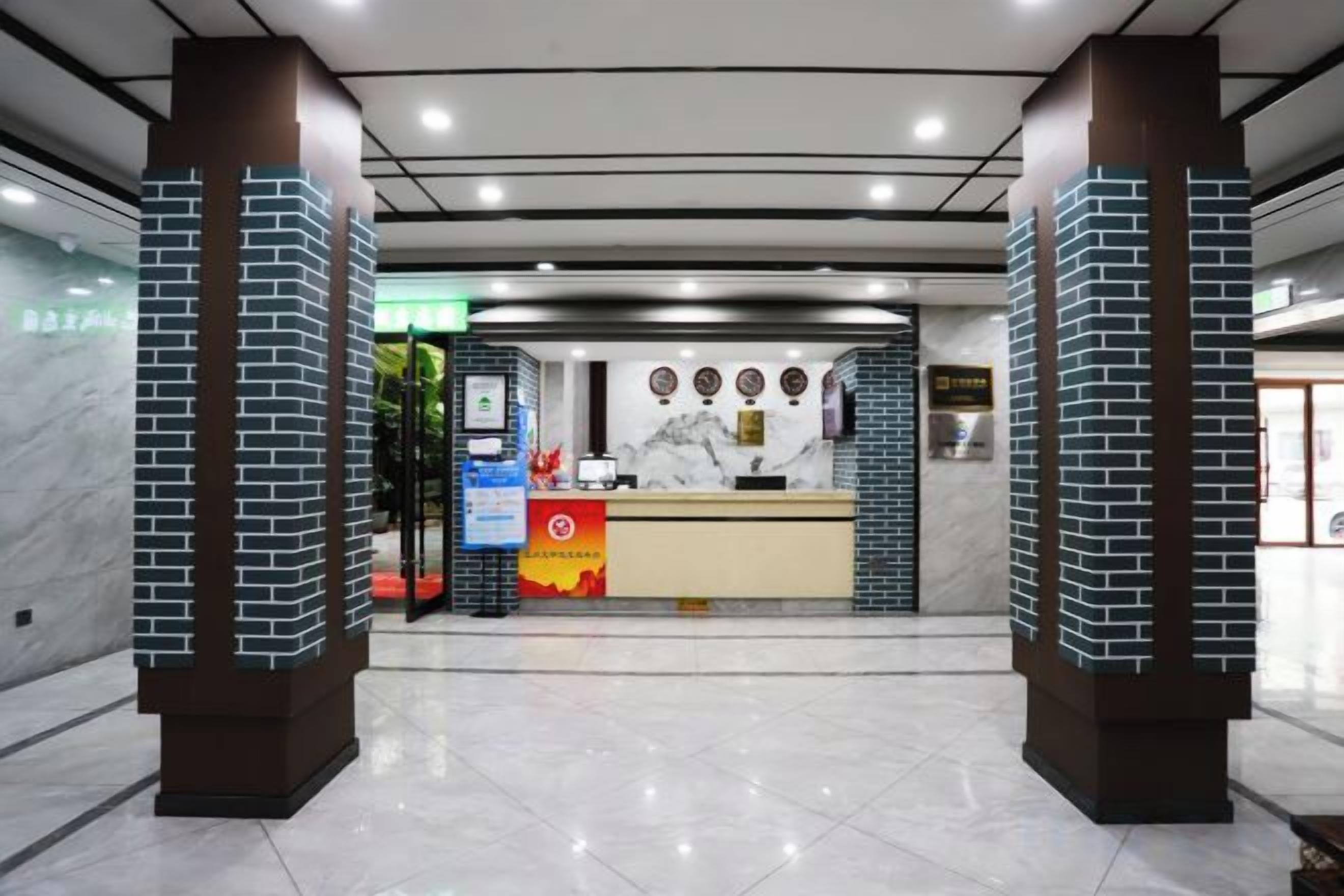 Un área de recepción con mostrador de mármol, una mesa de recepción y una puerta de vidrio que da a la recepción.